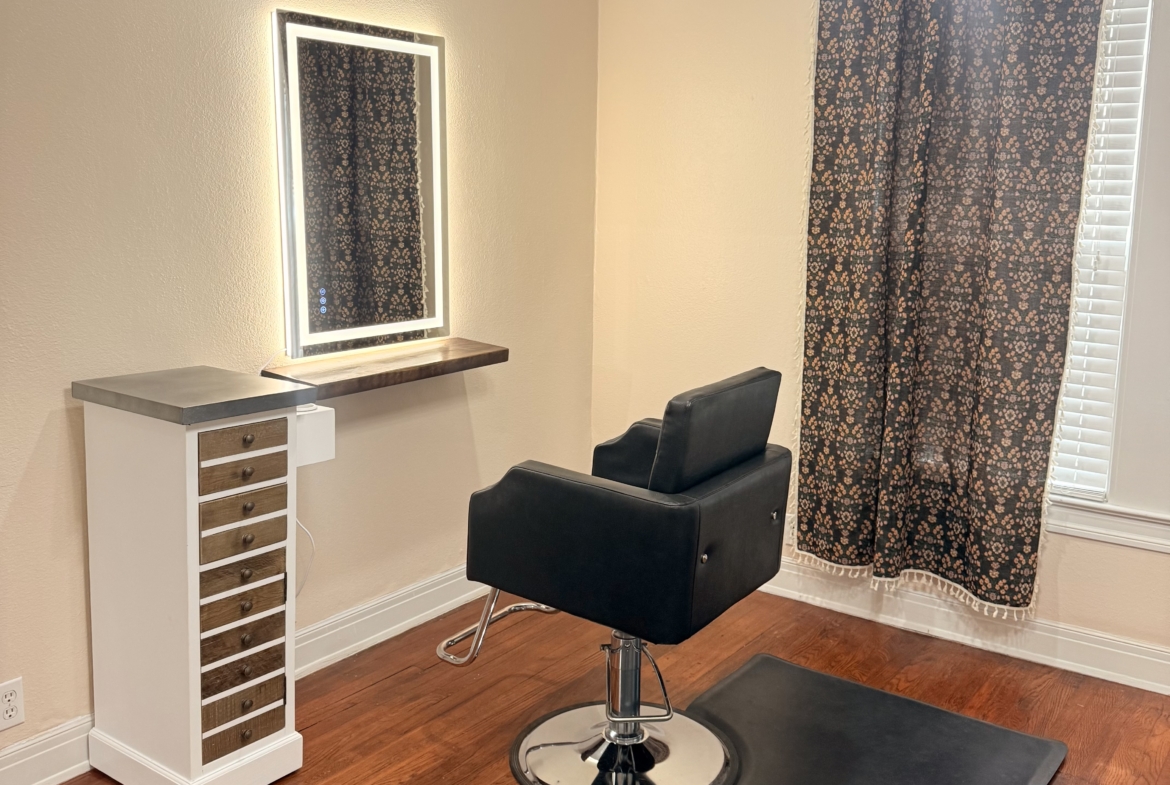 Stylish salon station featuring a comfortable styling chair and illuminated mirror.
