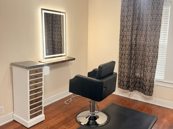 Stylish salon station featuring a comfortable styling chair and illuminated mirror.
