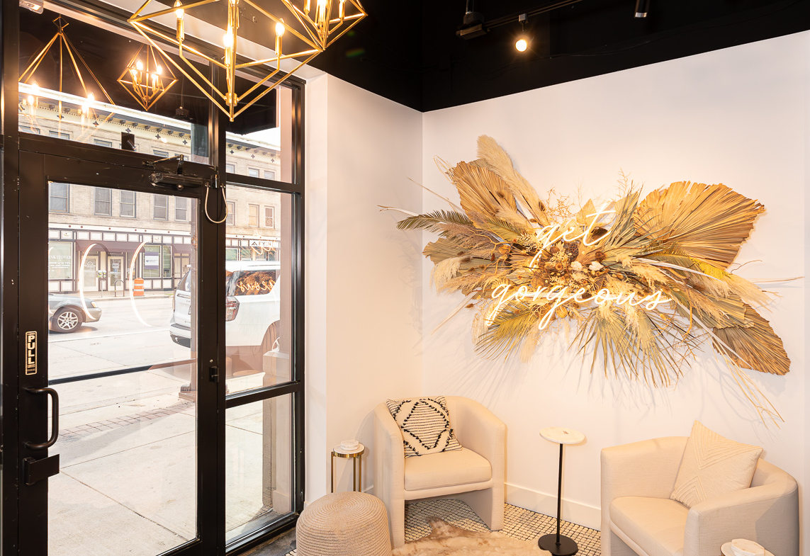 Stylish salon waiting area with comfortable chairs, natural decor, and welcoming ambiance.