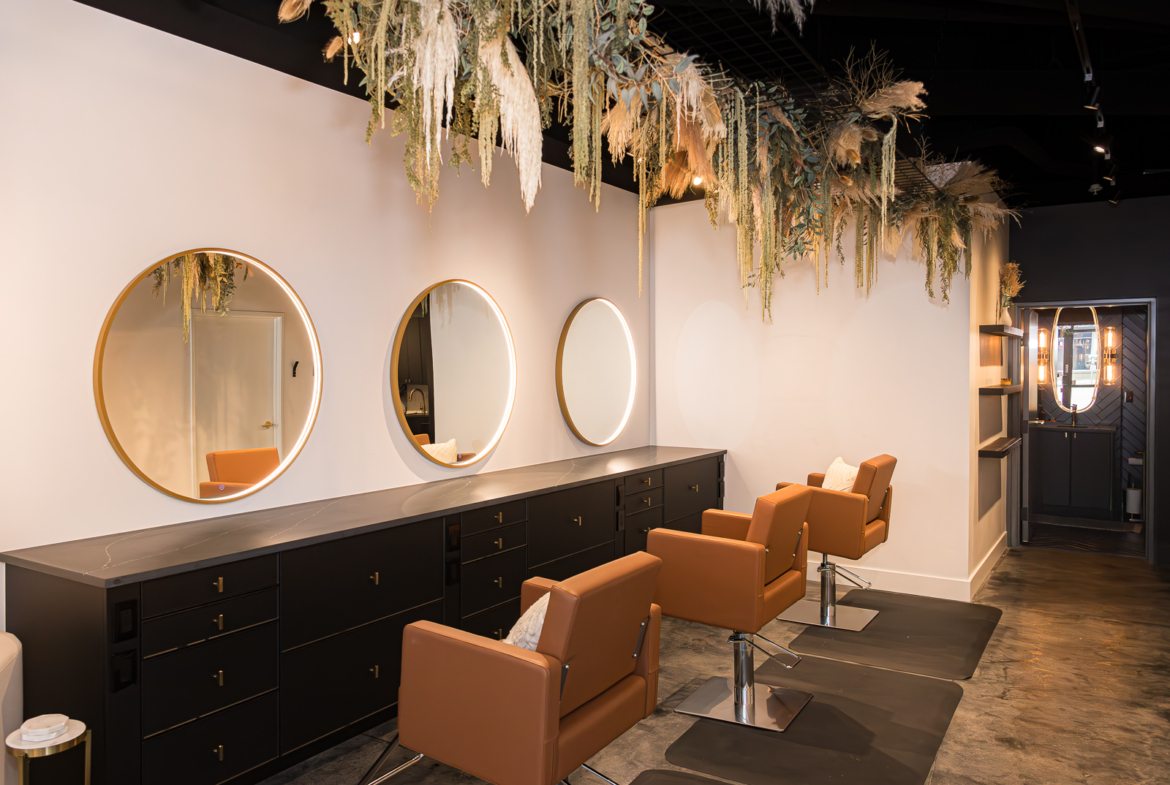 Elegant salon workspace featuring sleek mirrors, cozy chairs, and chic decor for optimal styling experiences.