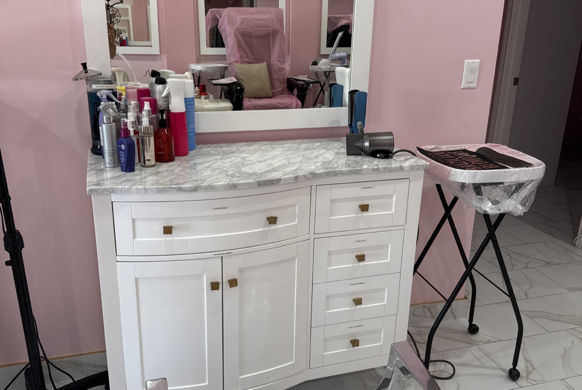 Beauty salon vanity with mirror, hair products, and styling tools for professional hair care.