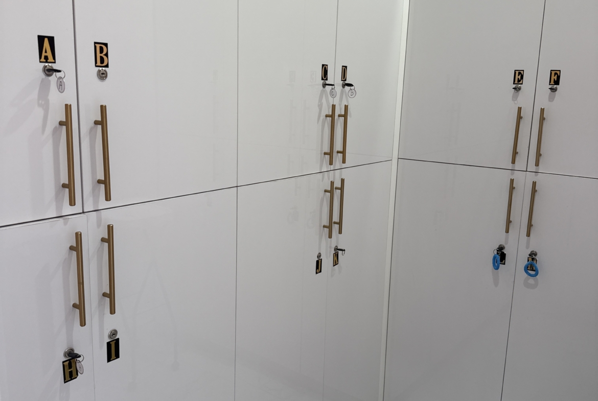 Bright white salon lockers with gold handles and labeled keys, perfect for salon or beauty suite storage.