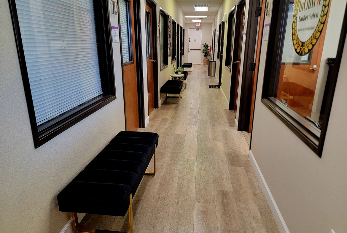 Modern salon office hallway with seating area and reception.