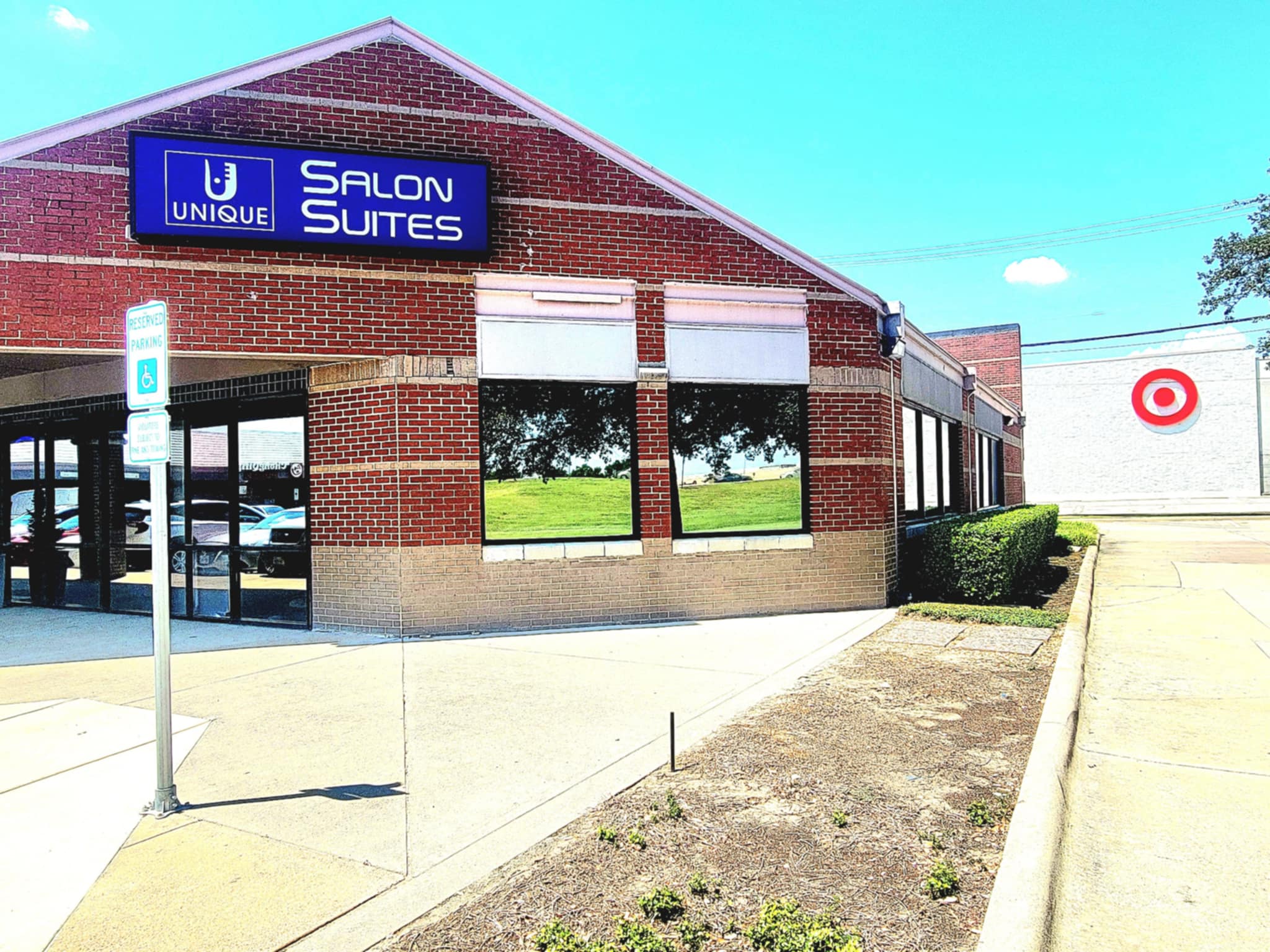 Modern brick salon suite building with large windows and parking lot.