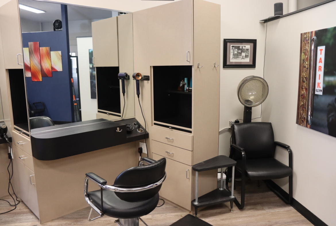 Stylish salon workspace with chairs, cabinets, hairdryer, and salon decor.