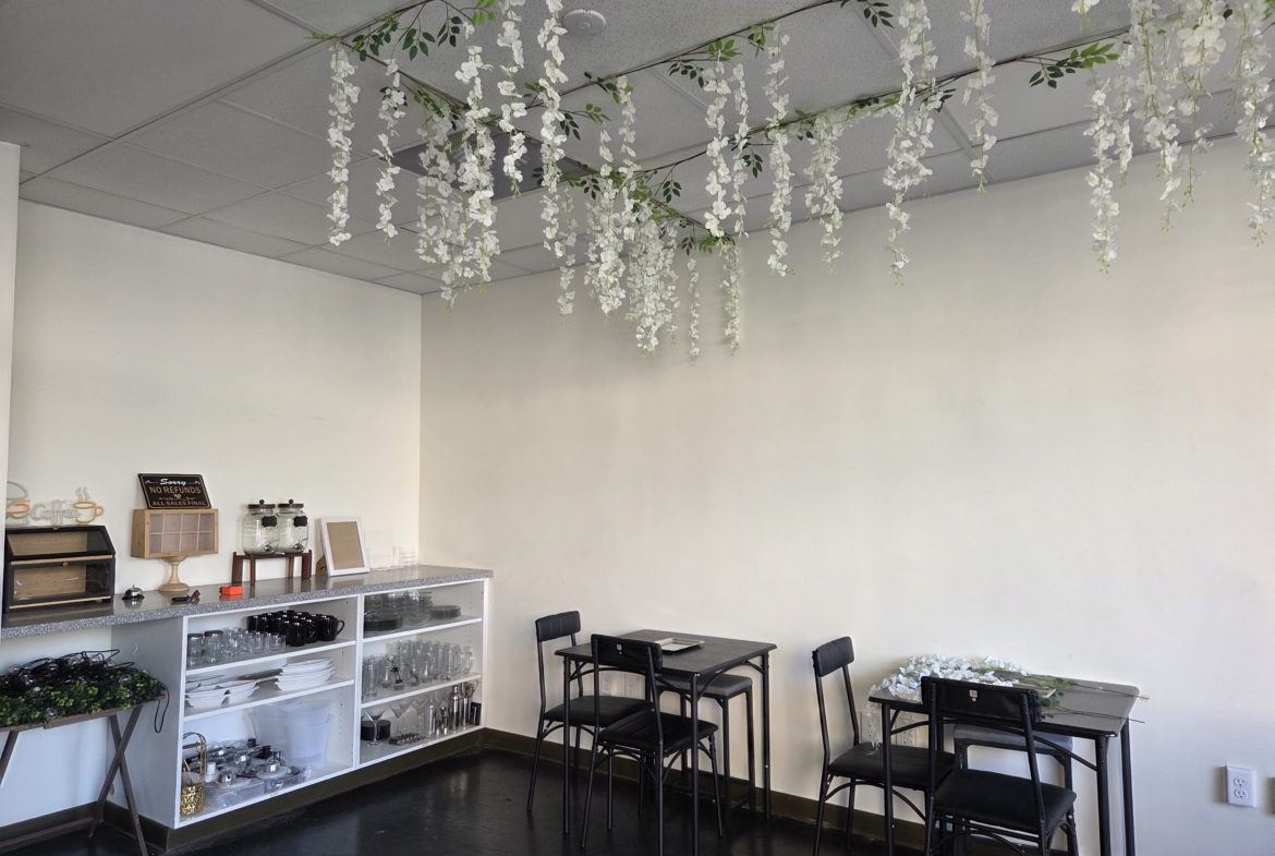 Bright salon interior with elegant white flower hanging decor and cozy seating area.