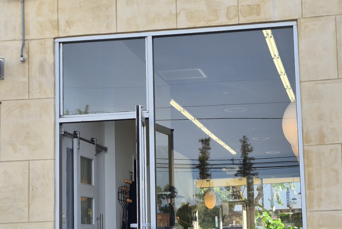 Modern salon entrance with large glass window and door, inviting ambiance for hair and beauty services.