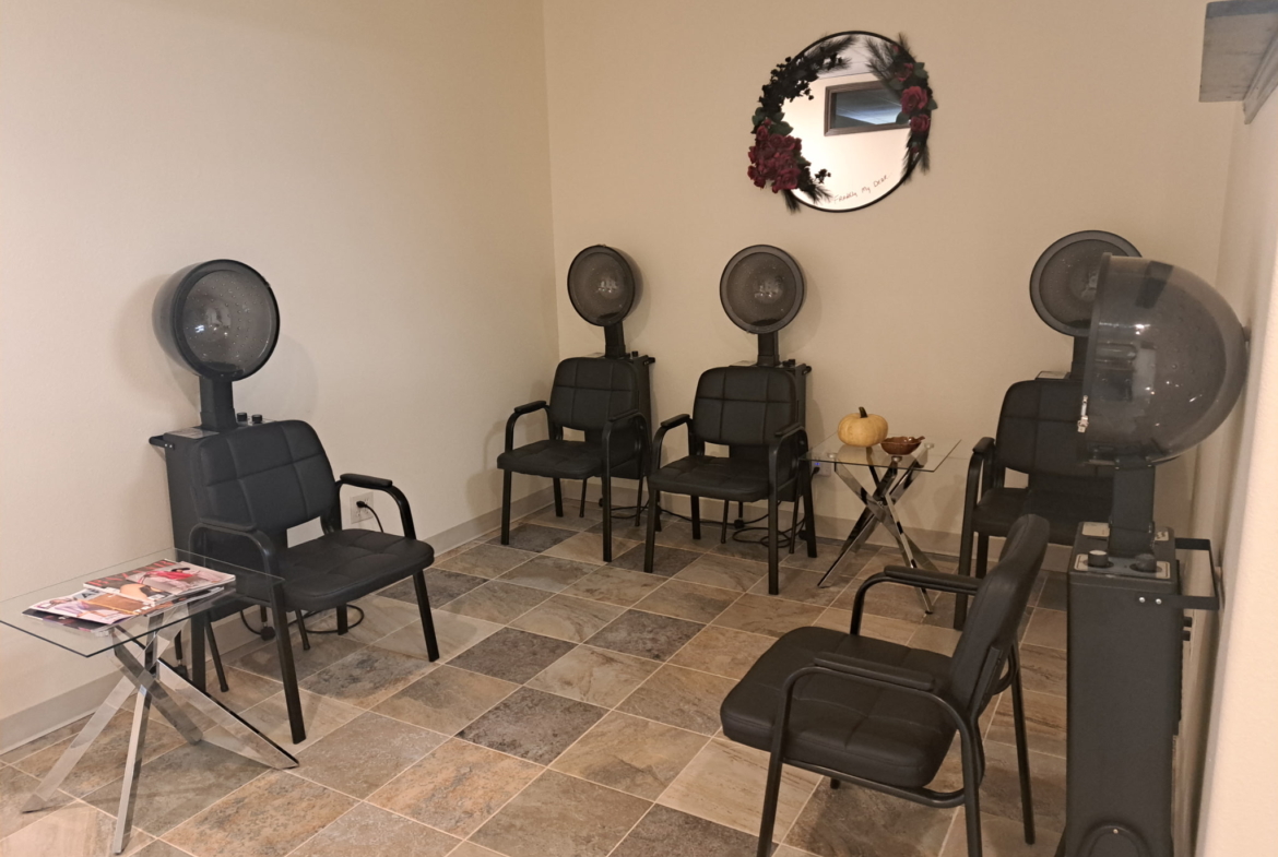 Hair salon with hair drying chairs and stations for clients and stylists.