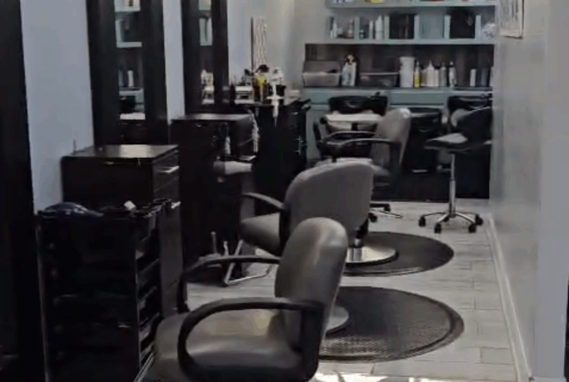 Sleek salon styling chairs with mirrors and organized shelving for hair and beauty services.