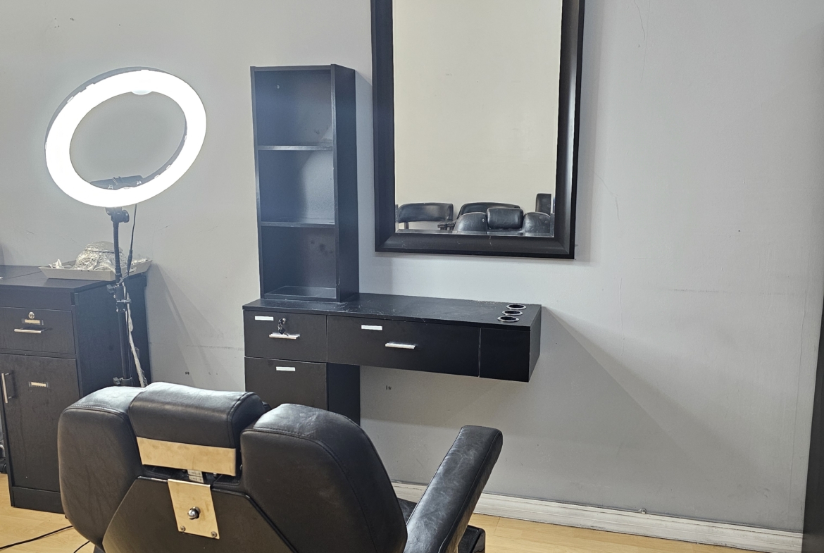 Professional salon setup featuring a barber chair, large mirror, and organized workstation.