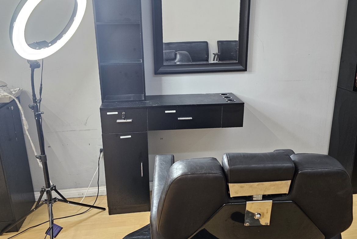 Clean salon station with mirror, counter, and professional styling chair for hair and beauty services.