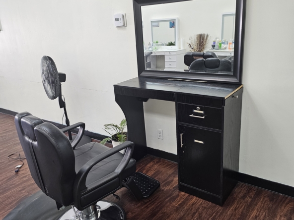 Stylish salon styling station with mirror and black furniture for beauty professionals.