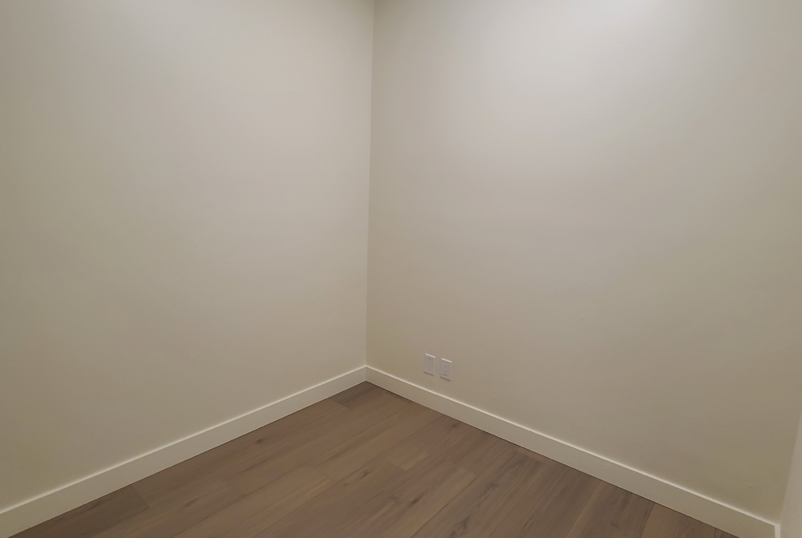 Bright empty salon room with hardwood floors and white walls, ideal for hair or beauty professionals.