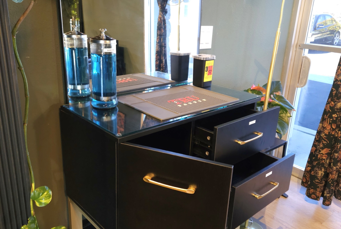 A modern salon station featuring drawers, mirror, and decor for hair and beauty professionals.