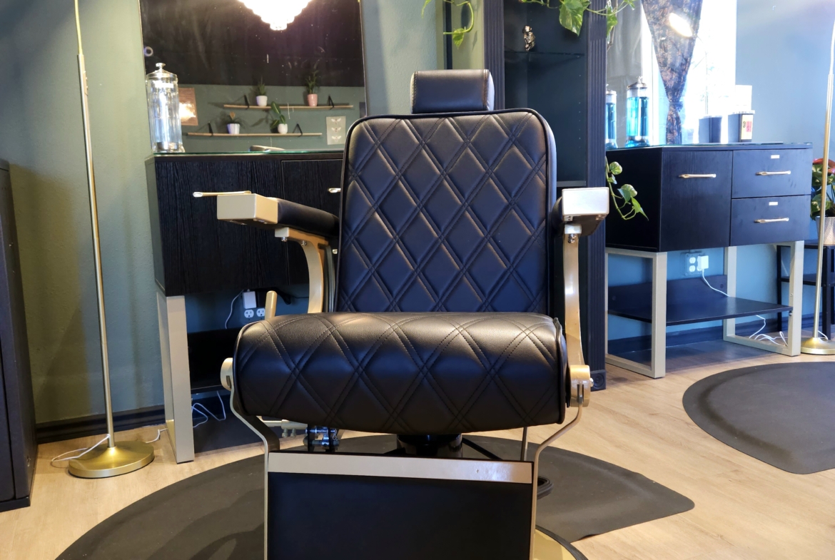 Stylish black salon barber chair with modern design for rental in professional hair salon.