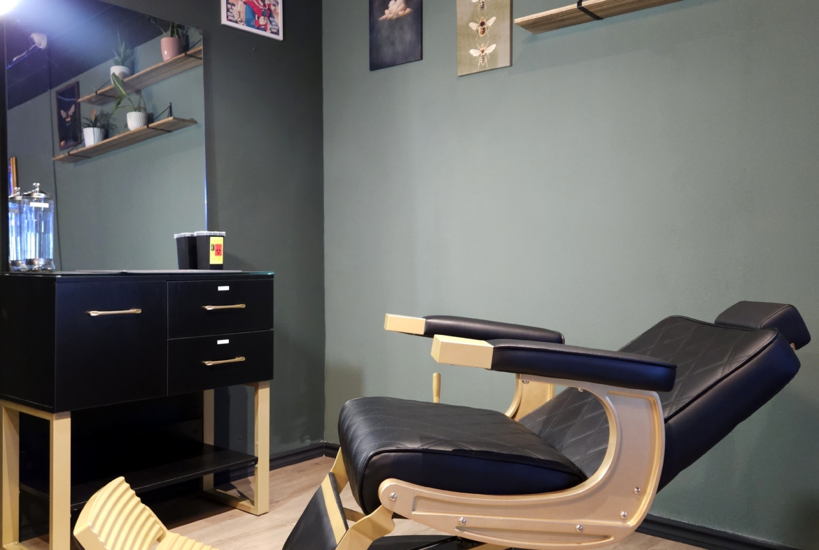 Comfortable barber chair in stylish salon interior with wall art and decorative plants.