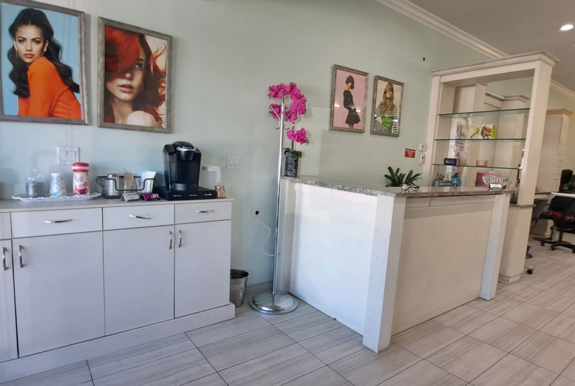 Bright salon reception and styling area with modern decor and hair salon furniture.