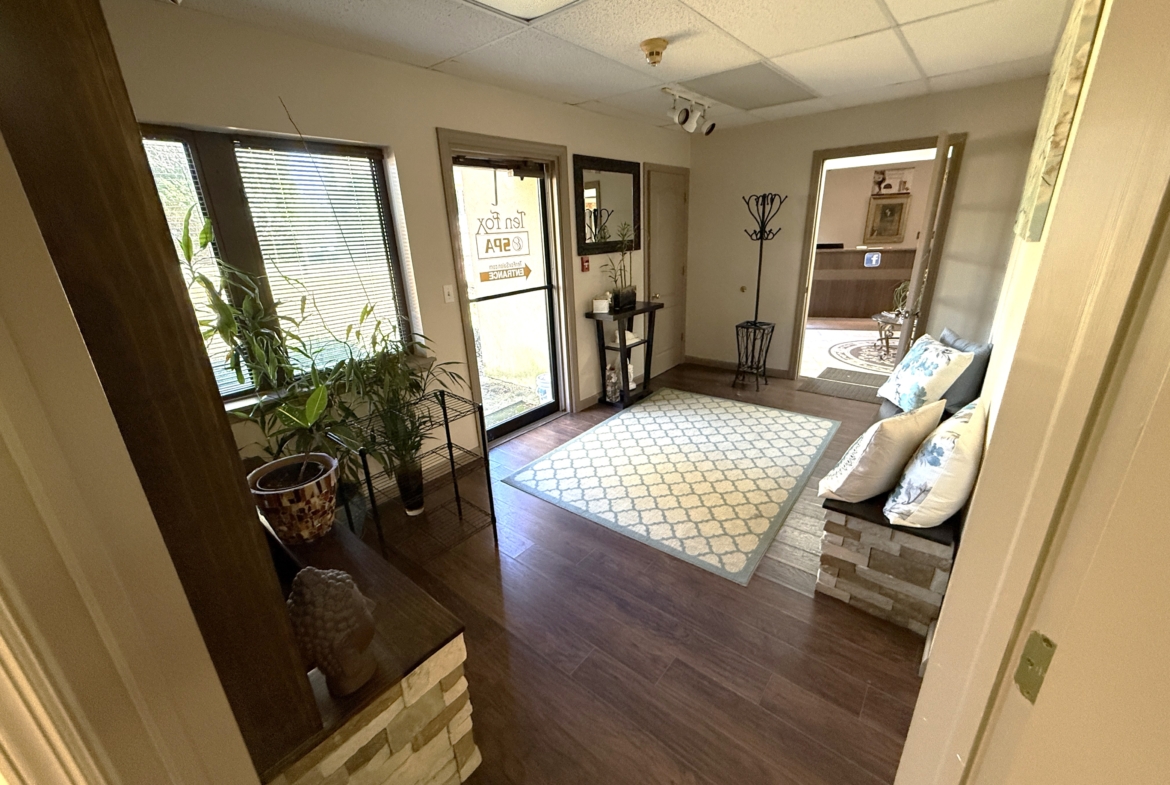Comfortable salon lounge area with pillows, plants, and welcoming atmosphere for clients.
