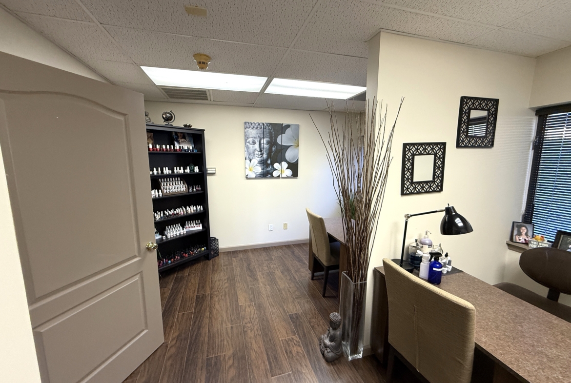 Well-organized salon space with nail polish shelves, decorative artwork, and professional manicure station.
