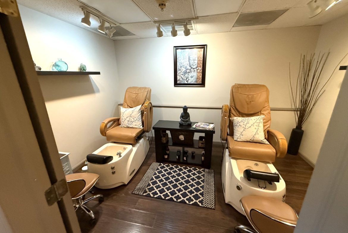 A cozy wellness treatment room featuring massage chairs, relaxing decor, and tranquil ambiance for spa and pedicure services.