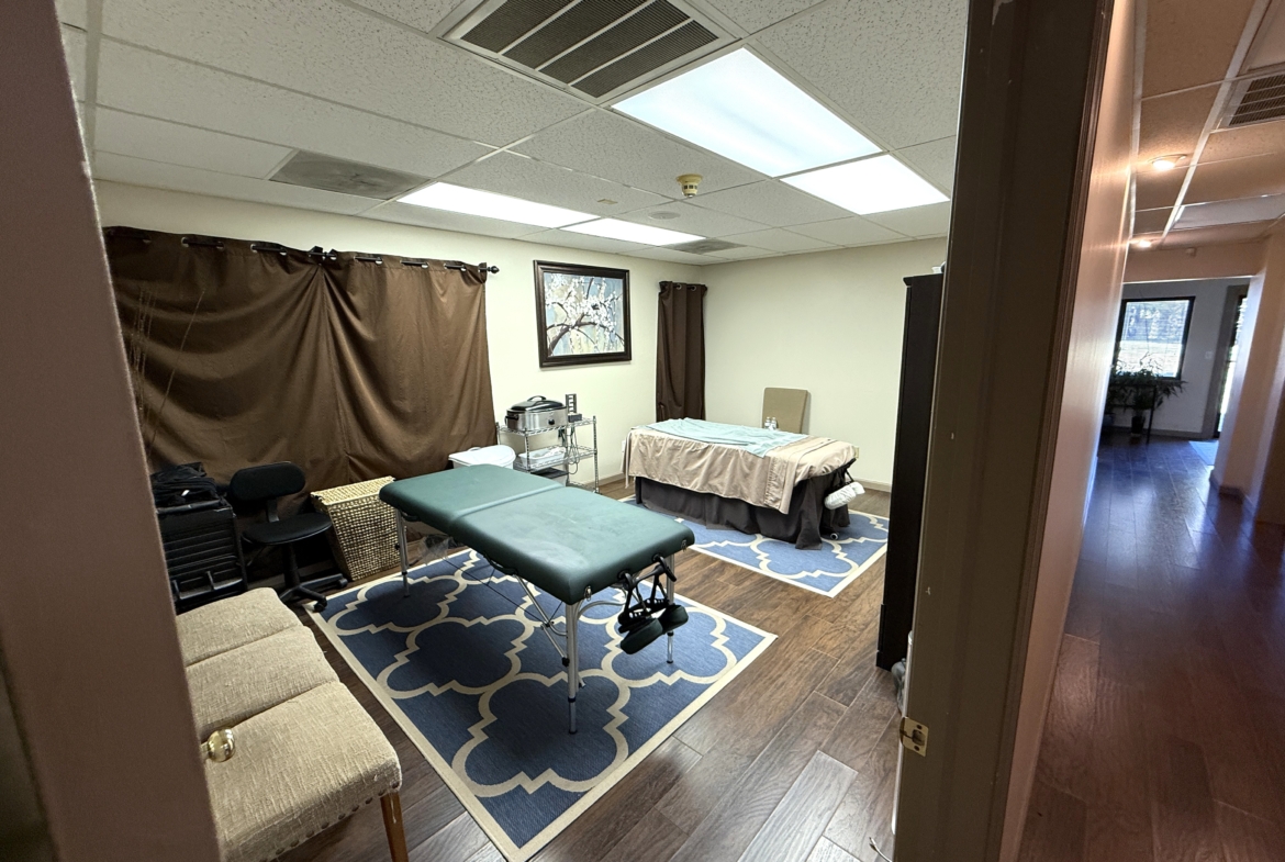 Comfortable massage room featuring a massage table, cozy decor, and calming atmosphere.