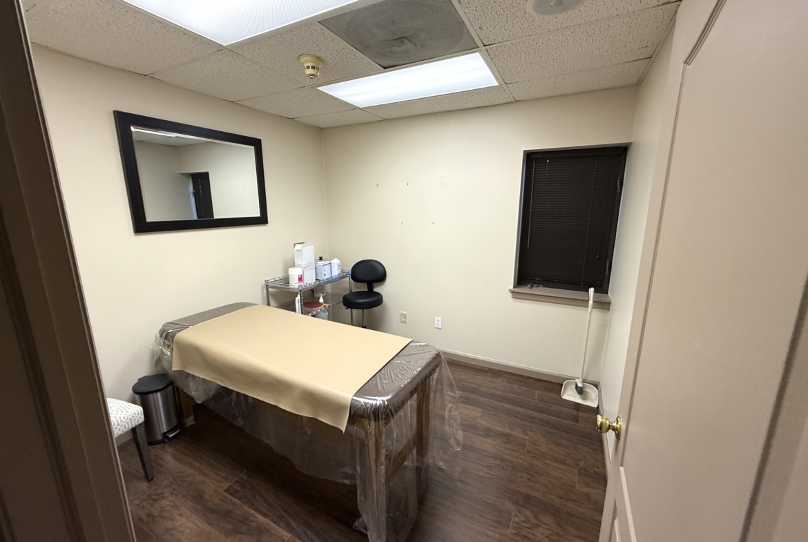 Small treatment room with massage table, mirror, and basic salon equipment for rent. Great space for beauty professionals.