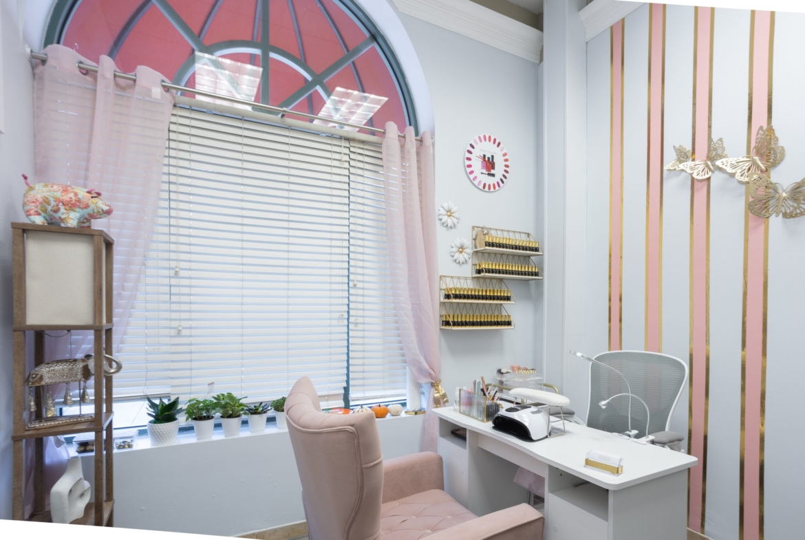 Bright salon interior with nail polish display shelves and manicure chair, ideal for rent-based beauty businesses.