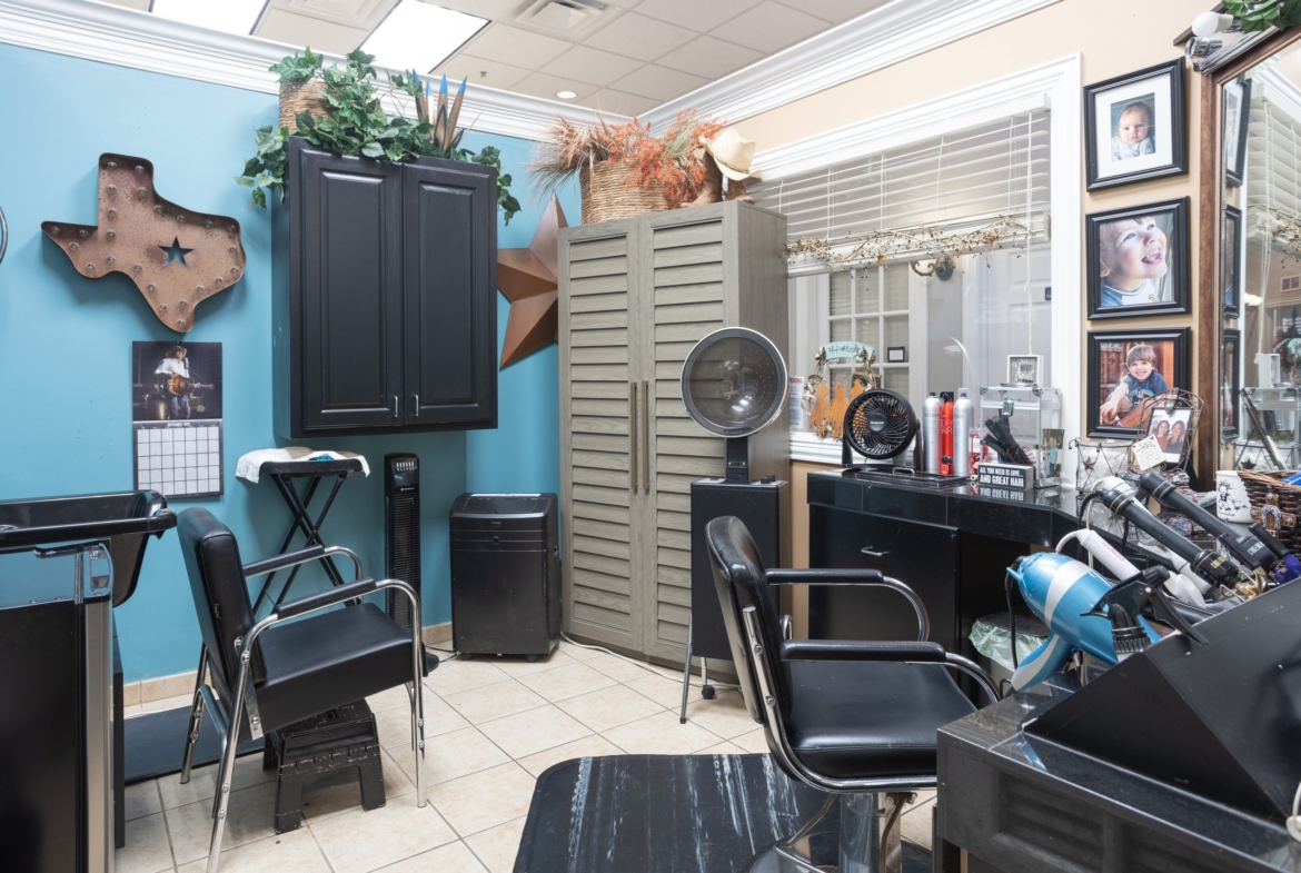 Versatile salon workspace with styling chairs, hair tools, decor, and photo wall for rent or leasing.