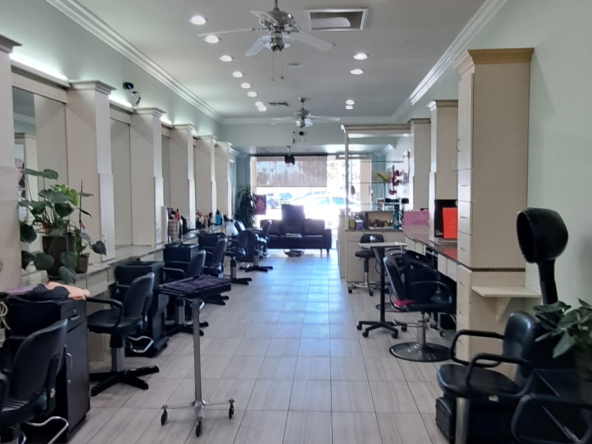 Salon interior with styling stations, chairs, and natural light.