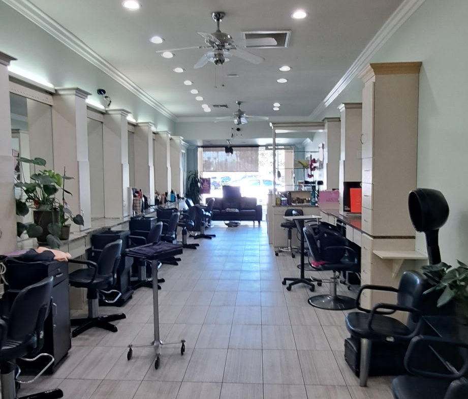 Salon interior with styling stations, chairs, and natural light.
