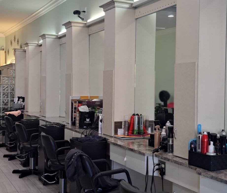 Modern salon styling stations with chairs and mirrors for hair cutting and styling.