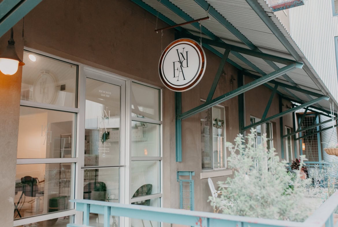 Chic salon storefront with modern signage and outdoor seating for beauty and hair services.