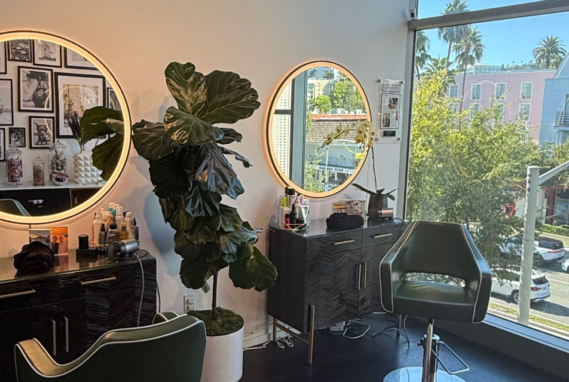 Stylish salon with chairs, mirrors, and beautiful city view through large windows.