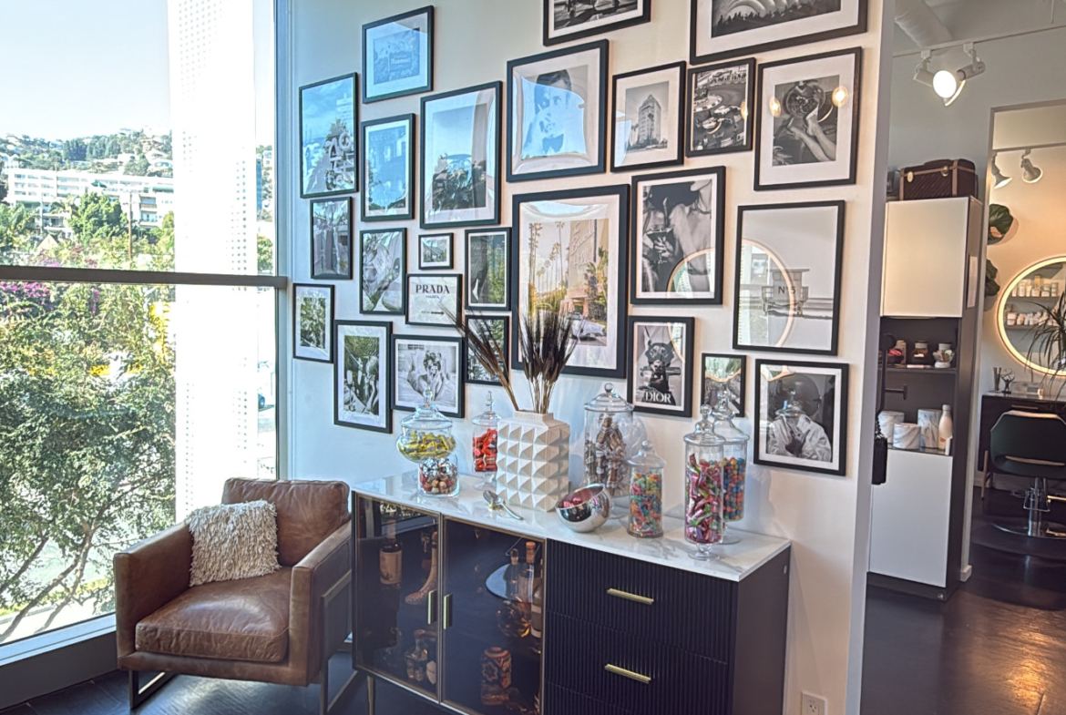Bright and trendy salon interior featuring gallery wall and seating area.