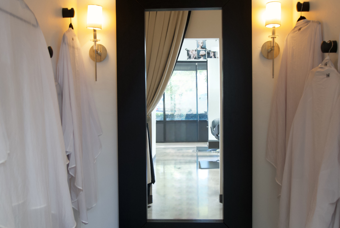 Elegant salon mirror with wall-mounted lights, ideal for hair and beauty salons rental.