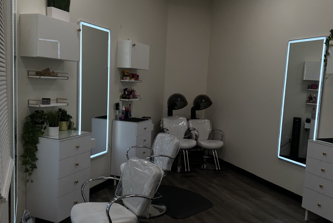 Bright salon with white furnishings, styling chairs, mirrors, and hair drying stations for rent.