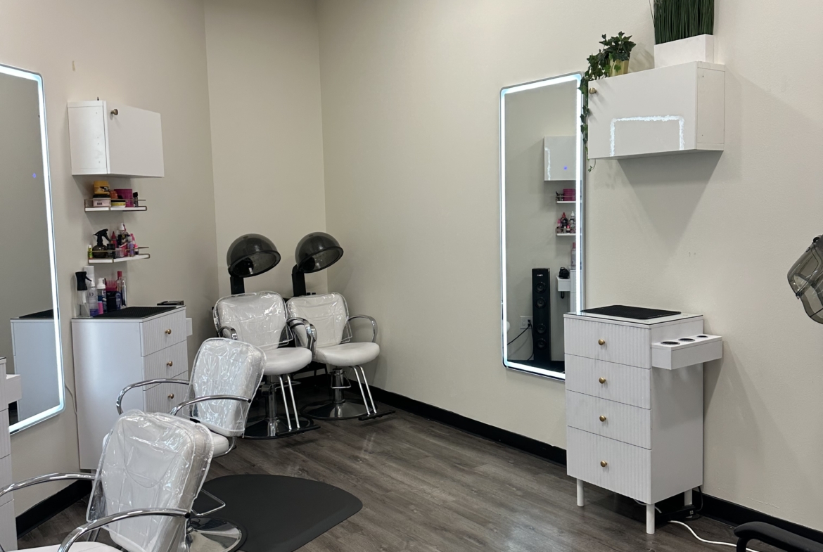 Clean salon interior with white styling chairs, styling stations, and hair drying stations.