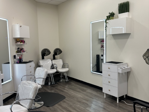 Clean salon interior with white styling chairs, styling stations, and hair drying stations.