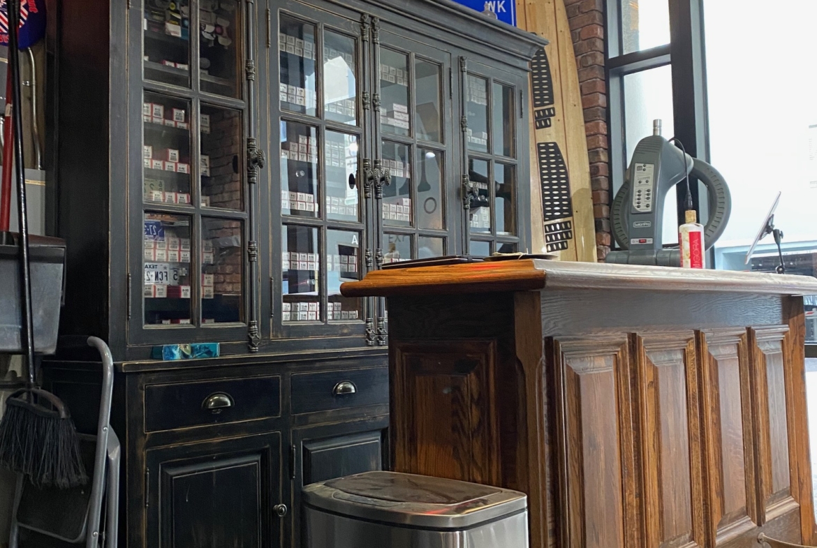 Stylish salon reception area featuring antique cabinet, countertop, and hairdressing equipment.