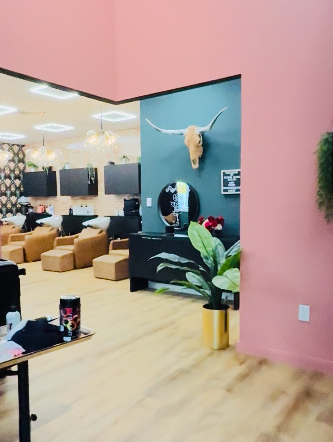 Stylish salon with vibrant decor, cozy chairs, and a polished wooden floor for a luxurious hair salon experience.
