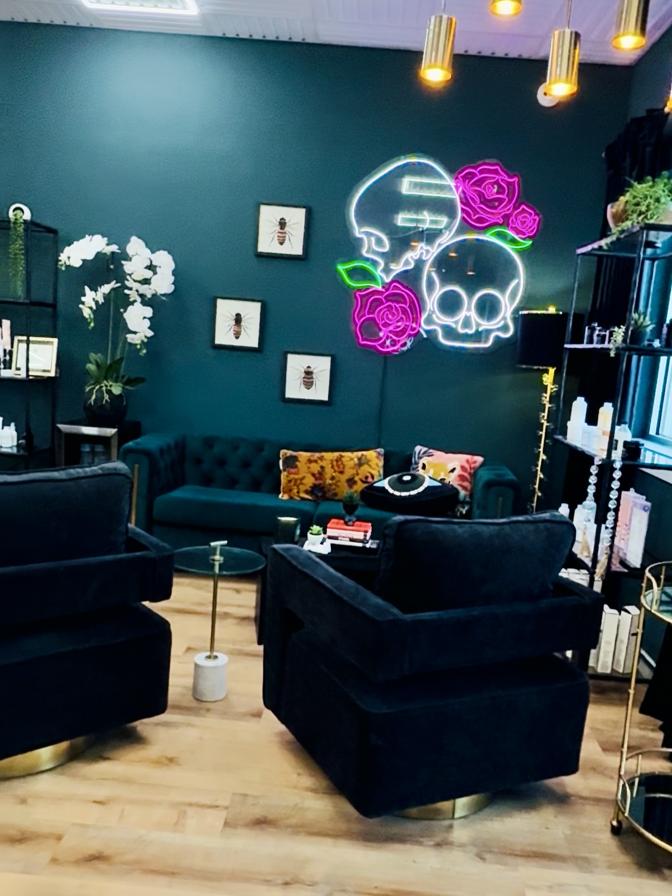 Vibrant salon lounge with neon skull and rose art, stylish decor, and cozy seating area.
