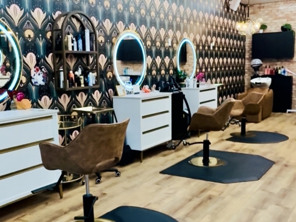 Stylish salon with illuminated mirrors and cozy chairs.