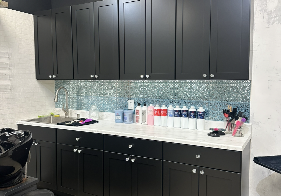 Salon supply storage cabinets with beauty products on countertop.