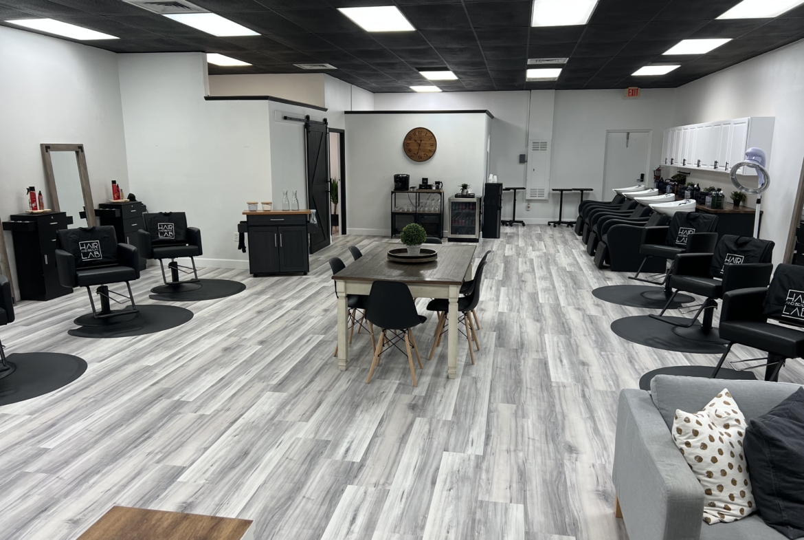 Modern salon interior with black chairs, wash basins, and a welcoming atmosphere for clients.
