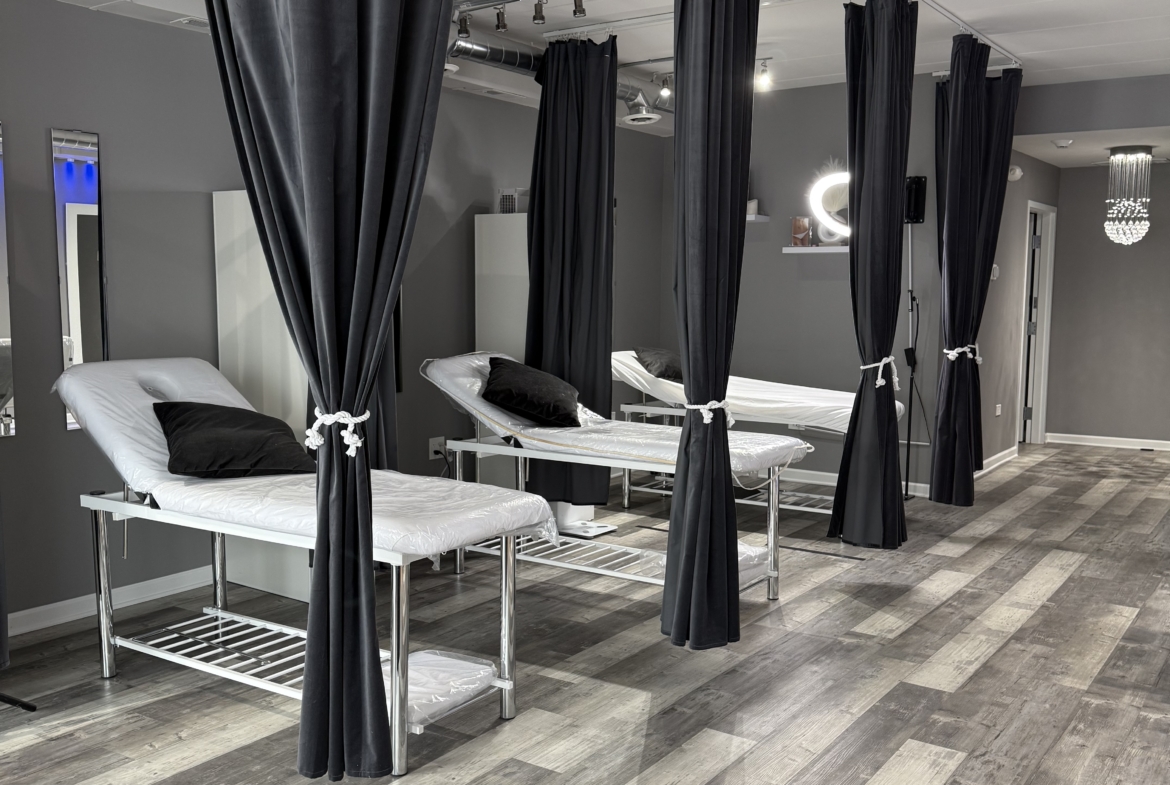Modern salon treatment area featuring privacy curtains and professional styling stations.