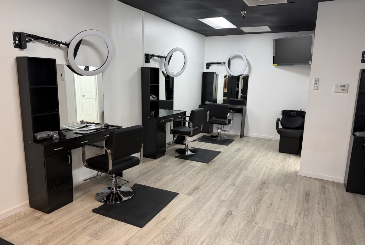 Professional salon hair styling stations with mirrors and ring lights.