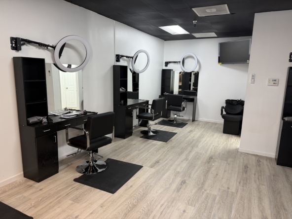 Professional salon hair styling stations with mirrors and ring lights.