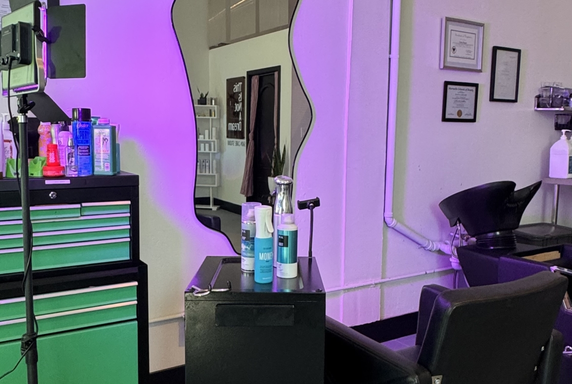 Mirror with unique wavy design at a salon rental space with styling chair and supplies.