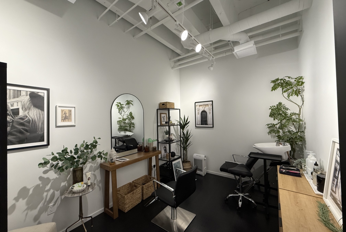 Stylish salon rental space with plants, mirrors, and professional styling chairs.