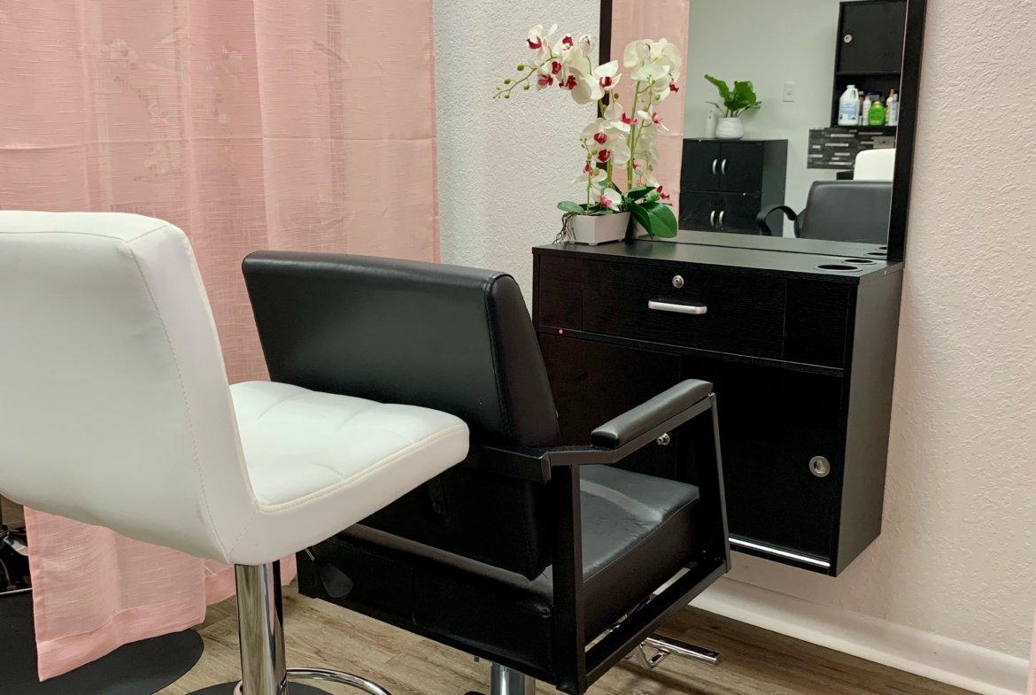 Stylish salon station with adjustable chair, large mirror, and elegant decor for hair styling.